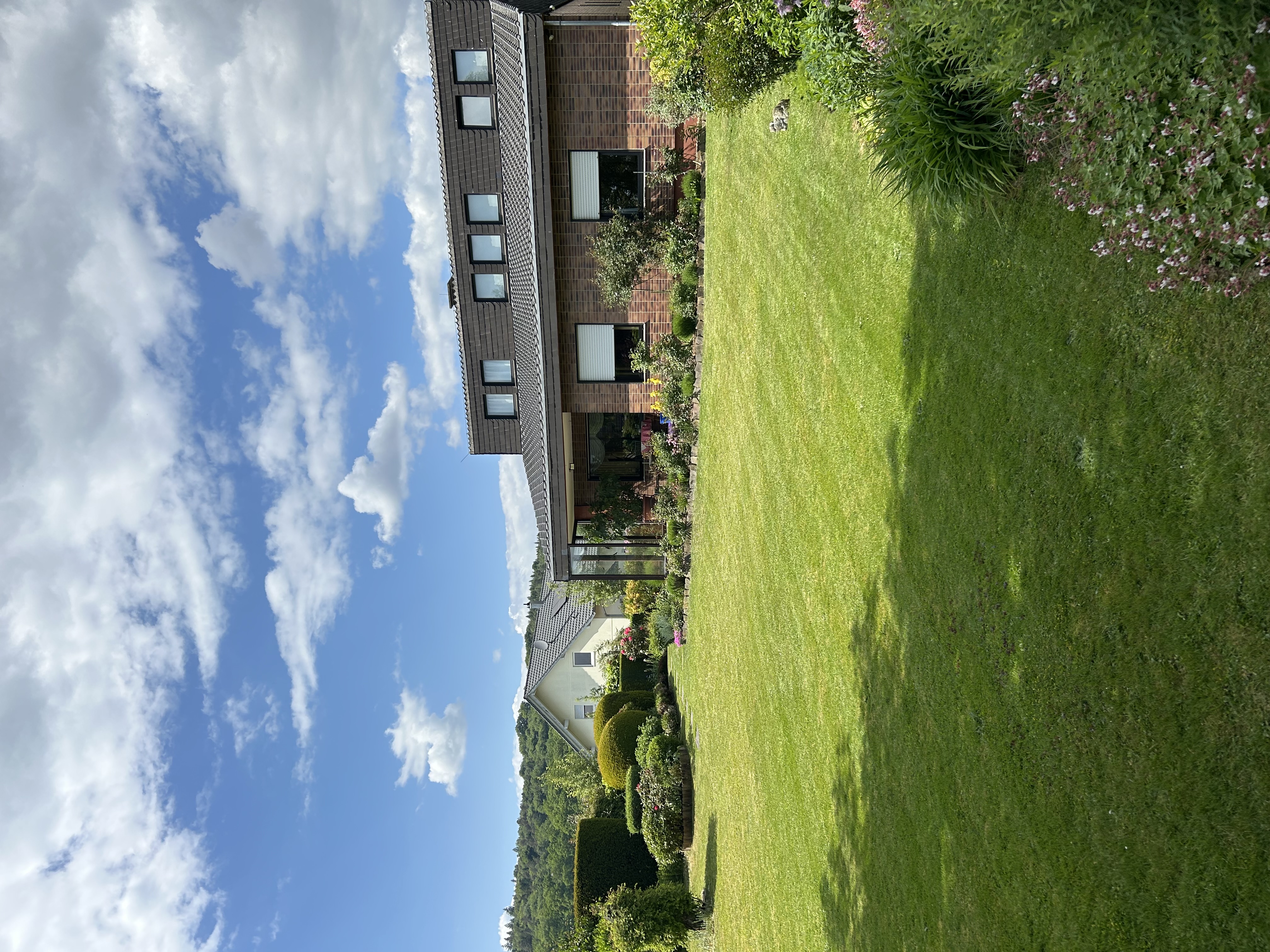 Gepflegter Garten mit Rasenfläche und Wohnhaus